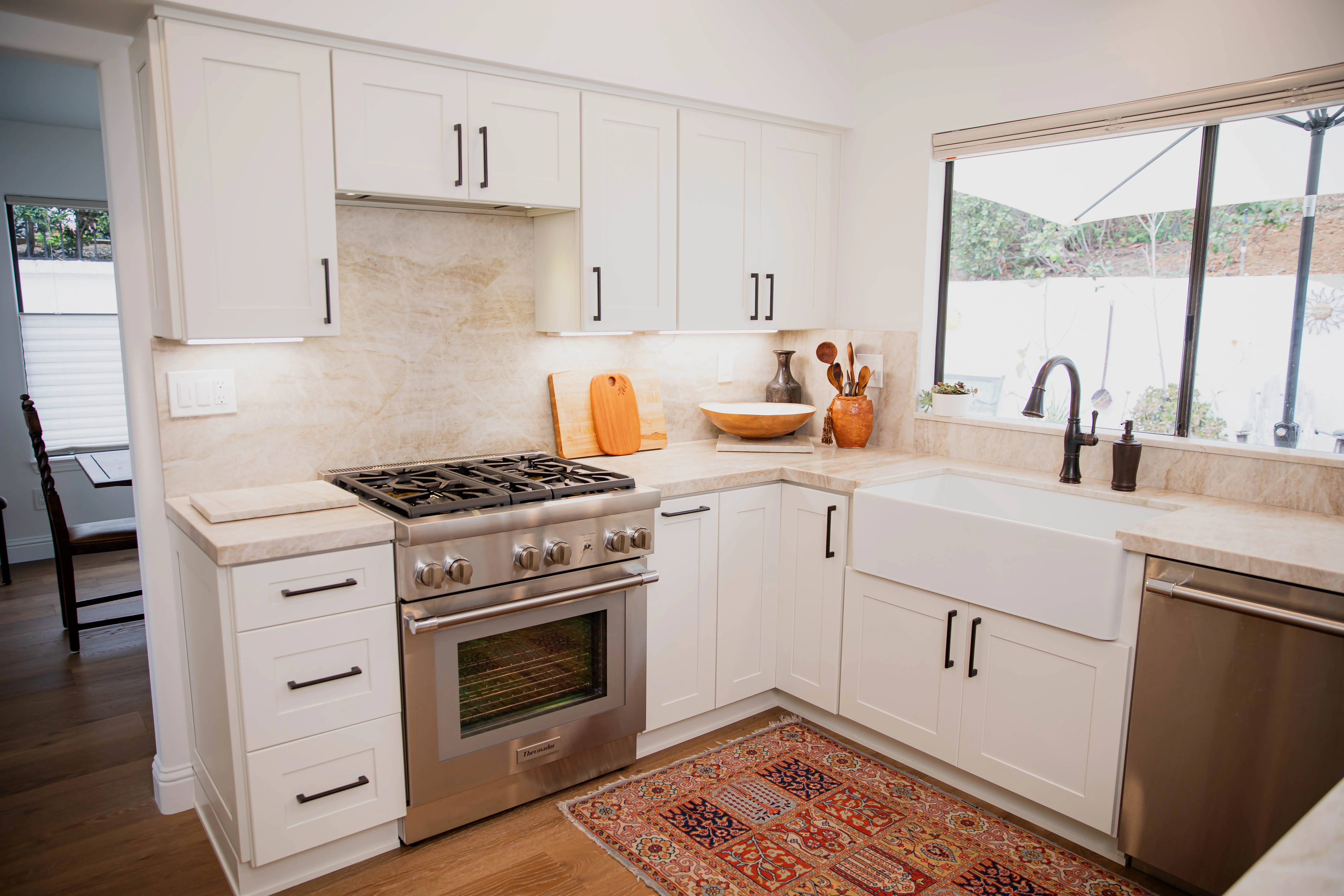 Fully remodeled San Diego home interior showing an open-concept kitchen and living area with updated flooring, recessed lighting, and modern cabinetry. The renovation reflects a cohesive design across multiple rooms completed by Home 360 Construction.