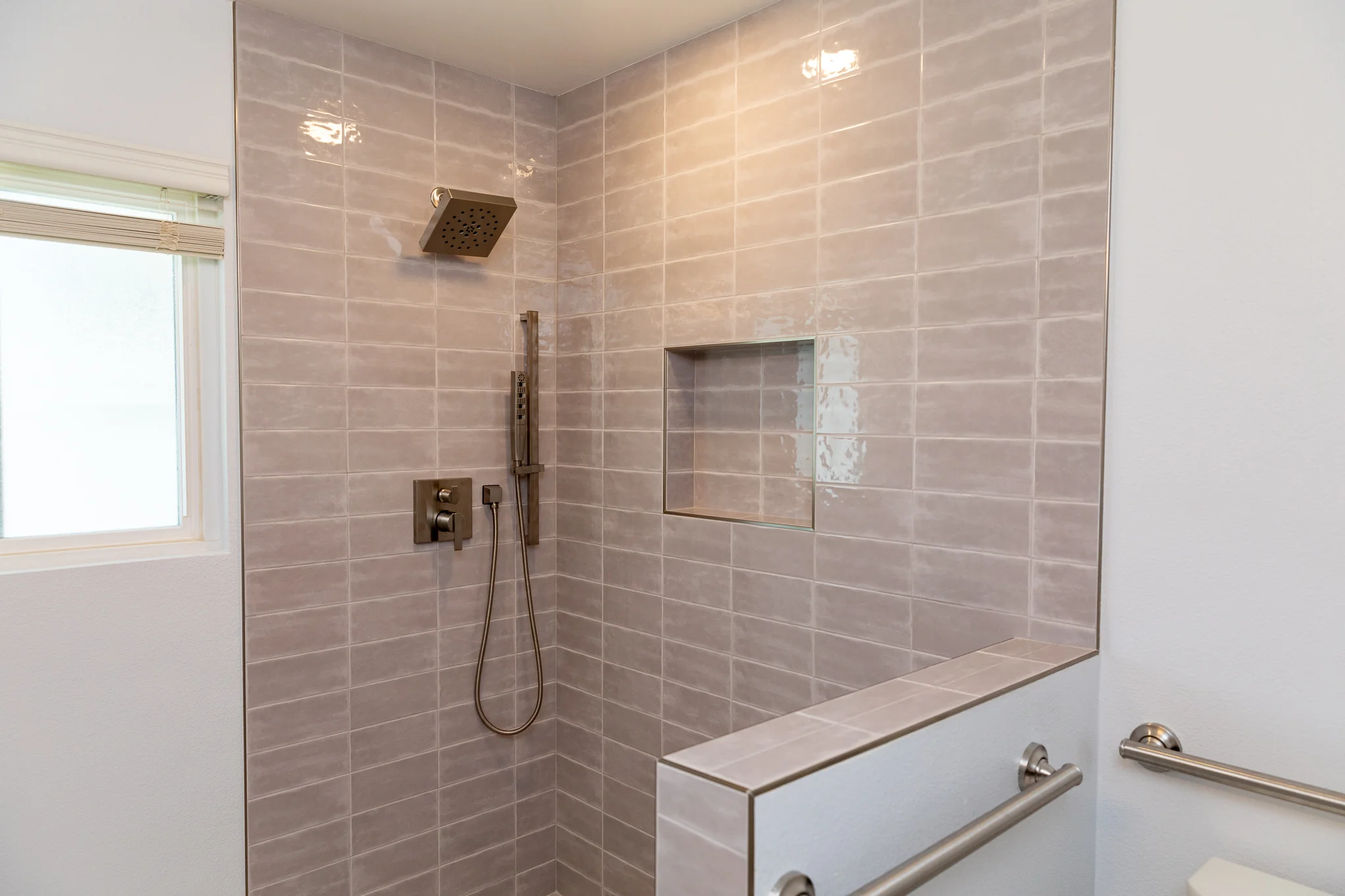 Freshly installed floor and wall tile in a San Diego bathroom remodel by Home 360 Construction, showing a tiled walk-in shower surround with consistent grout lines and a matching floor. Clean edge cuts meet the vanity base in a bright, modern bathroom interior.